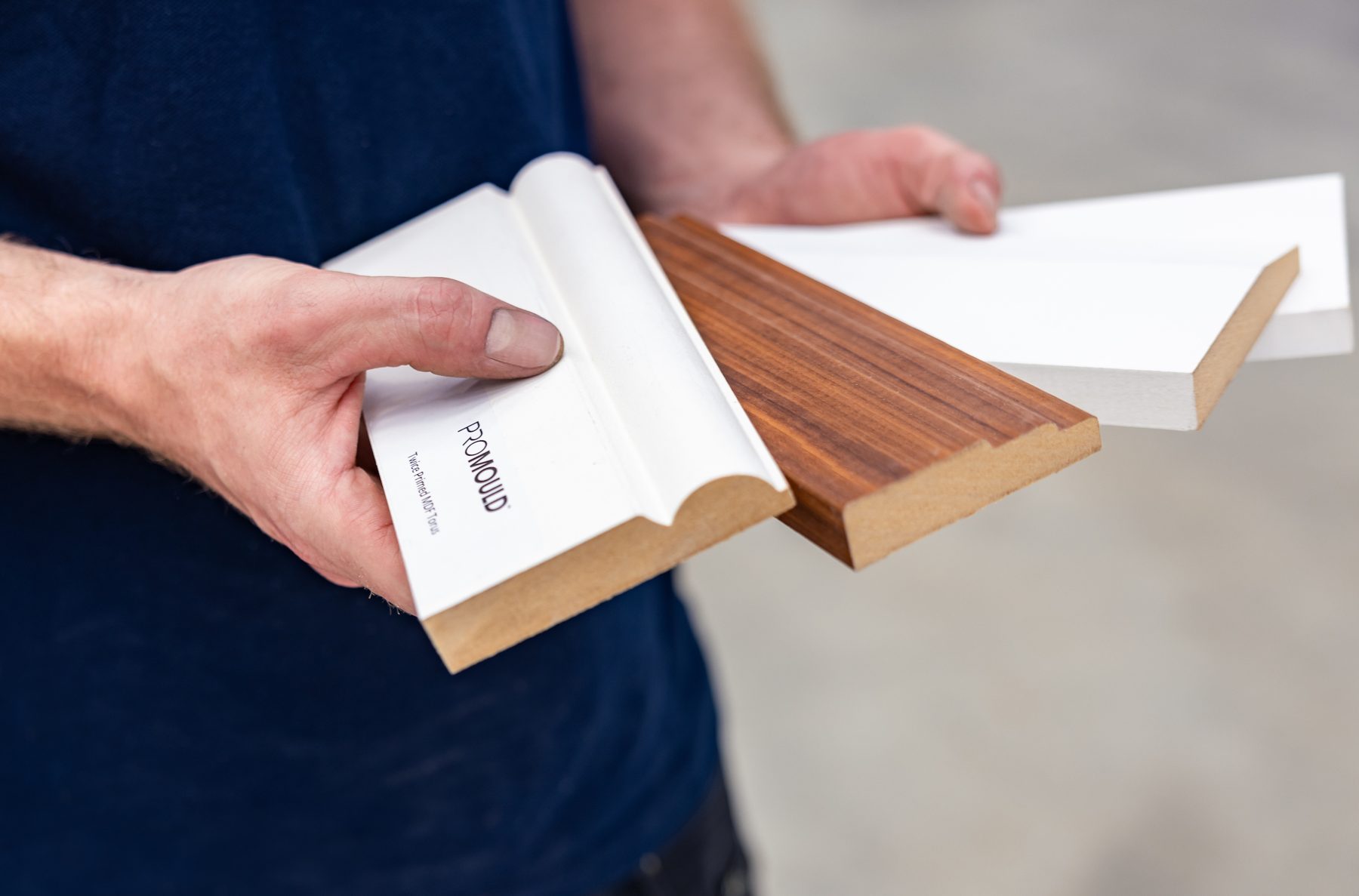 Promould twice primed torus, veneered and square edge samples held in hand